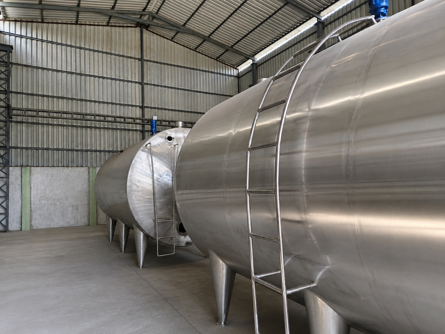 Stainless steel milk storage tanks built by a food processing machinery manufacturer in Pune